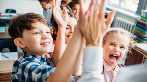Grundschulkinder klatschen sich ab