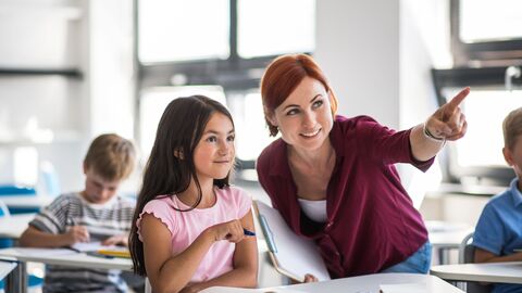 Eine sonderpädagogische Fachkraft hilft einer Schülerin.