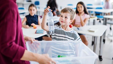 Junge sammelt Platikflasche. 