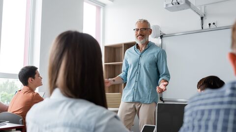 Älterer Lehrer unterrichtet eine Klasse.