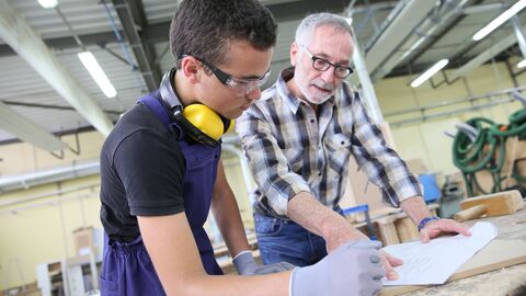 Berufsschullehrer spricht mit Schüler. 