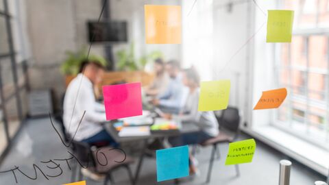 Notizzettel kleben an einer Glasscheibe.