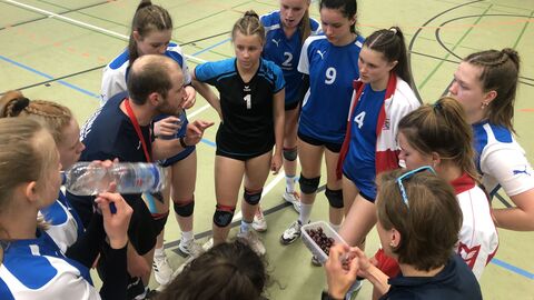 Volleyballerinnen im Gespräch mit ihrem Trainer