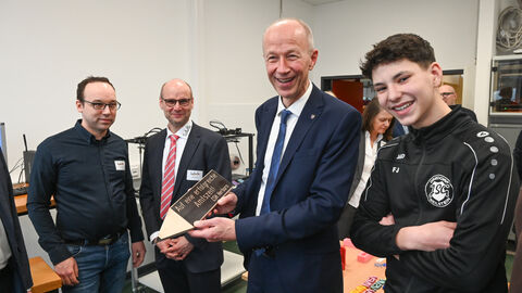 Armin Schwarz erhält ein selbstgemachtes Geschenk von zwei Schülern.