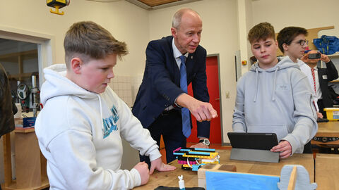 Ein Schüler zeigt Armin Schwarz etwas auf seinem Laptop.