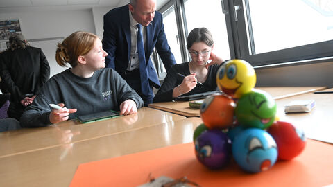 Zwei Schülerinnen im Gespräch mit Armin Schwarz.