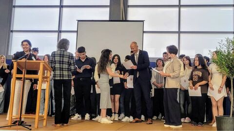 Kultusminister Schwarz gemeinsam übergibt Jugendlichen ihre Diplome auf einer Bühne.
