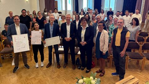 Mehrere Personen stehen zusammen und halten Auszeichnungen in die Kamera.