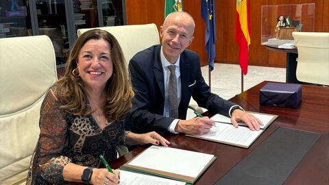 María del Carmen Castillo Mena und Bildungsminister Armin Schwarz sitzen an einem Tisch und unterzeichnen Unterlagen.