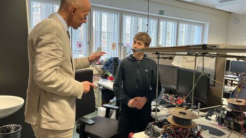 Minister Armin Schwarz im Austausch mit einem Schüler, der am Bundesentscheid von „Jugend forscht“ teilgenommen hat, gemeinsam an einem 3D-Drucker